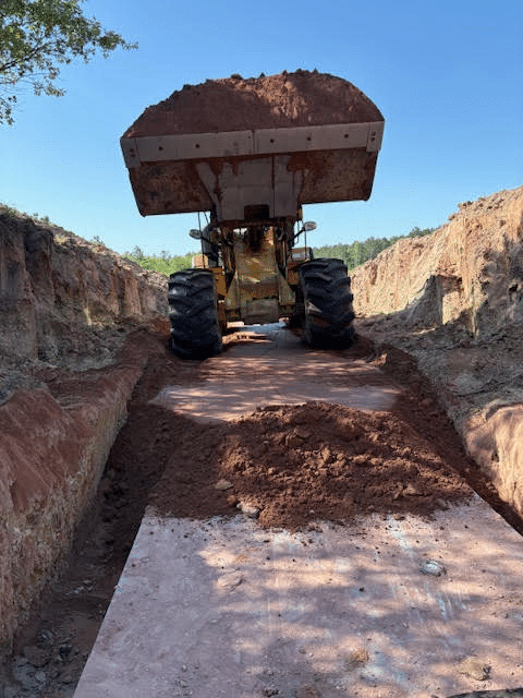 An excavator truck picking up soil on the ground An excavator truck picking up soil on the ground